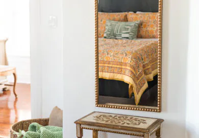 Orange Bedroom bed reflected in a mirror in the suite.