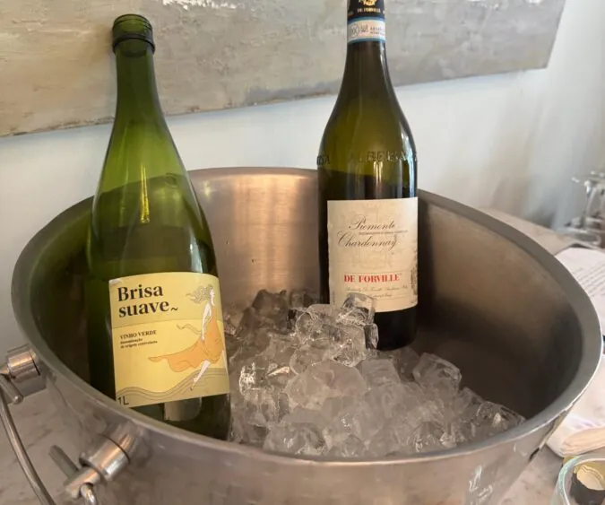 Image of two white wines chilling in a silver ice filled bath waiting to be poured.