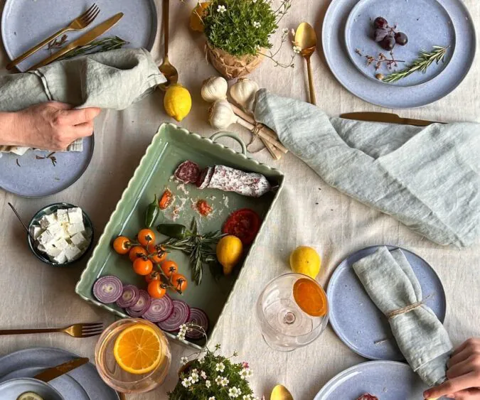 photo of a beautiful table set for dinner with plates of food, napkins, and other linens.